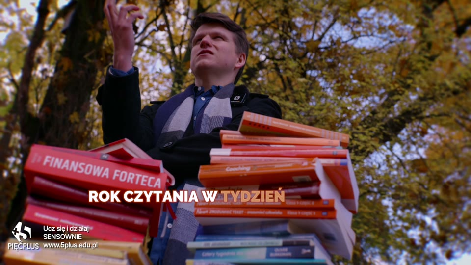 Kadr ze spotu — bohater ze stertą podręczników w jesiennym parku, reklama kursu szybkiego czytania